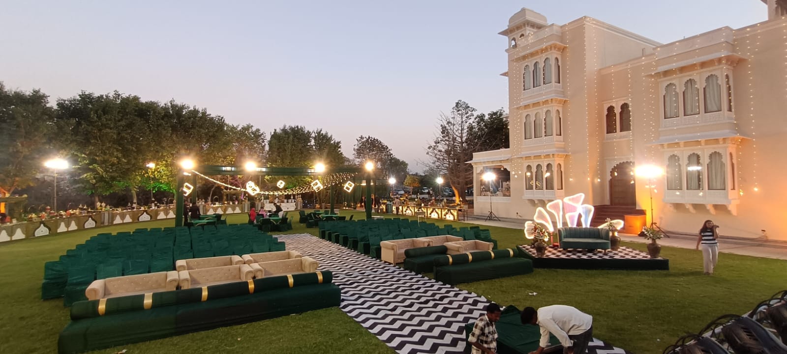 Palace lawn wedding setup at dusk with lounge seating